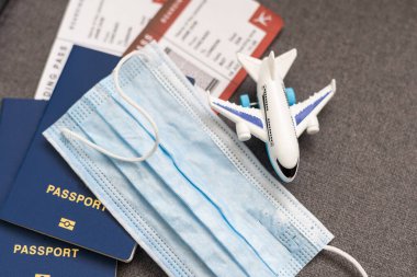 Corona virüsü maskesi nedeniyle COVID-19 seyahat kısıtlaması. Havaalanında ve Avrupa 'ya uçak seferlerinde zorunlu takılıyor. Pasaport, bilet ve tatil için hazır.