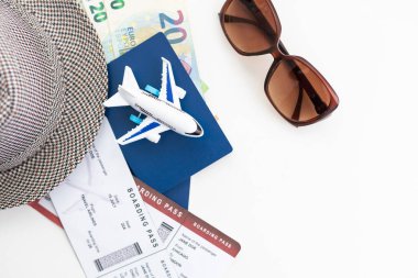 Beyaz arka plan görünümlü pasaport ve şapkalı turistik şeyler.