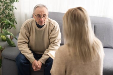 Psychology, depression people. Elderly adult man, men consulting with psychologist, psychiatrist while elderly, old patient counseling mental with doctor woman at clinic. Encouraging, therapy.