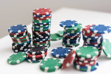 Beyaz arkaplanda çok renkli poker çipleri var. Yatay olarak yakın çekim. Başka benzer çekimler de mevcut. Yüksek kalite fotoğraf