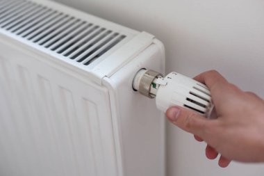 Odadaki ısıtma radyatörünün termostat valfini ayarlıyorum. Yüksek kalite fotoğraf