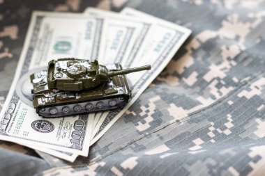 Dolar banknotlarının arka planında oyuncak tankı var. Yüksek kalite fotoğraf