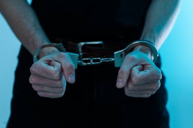 Demir hapishaneyi, mahkum konseptini hapisteki bir mahkumun ellerini kelepçelemek isteyen genç bir adam, erkek mahkumlar karanlık bir hapishanede şiddetli bir şekilde zorlandılar, şiddet, şiddet. Yüksek kalite fotoğraf