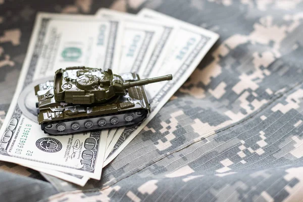 Dolar banknotlarının arka planında oyuncak tankı var. Yüksek kalite fotoğraf