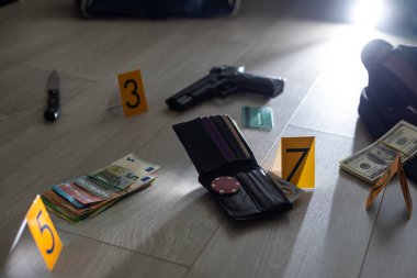 Olay yeri inceleme konsepti, tabanca ve mermi kovanına karşı apartmanın zeminindeki sarı işaret. Yüksek kalite fotoğraf