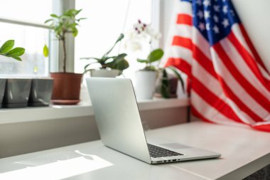  ABD bayrağı merkez ofiste dizüstü bilgisayarla çalışıyor. Yabancı iş, eğitim ya da Amerika 'ya göç için çevrimiçi olarak İngilizce öğreniyor. Yüksek kalite fotoğraf