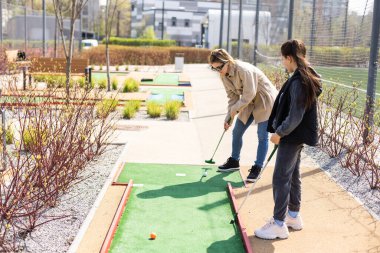 Anne mini golfte sevimli kızıyla oynuyor..