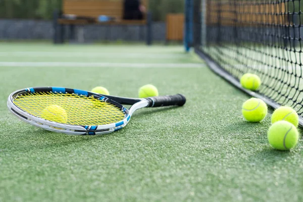 Profesyonel tenis raketi topu yeşil kortta, tenis ekipmanı yerde, yakın plan. Yüksek kalite fotoğraf