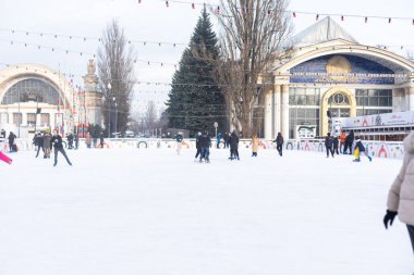 KYIV, UKRAINE - 23 Aralık 2022: buz pateni insanları. İnsanlar buz pateni sahasında eğleniyor. Kyiv 'de yeni yıl tatili. Kyiv Noel ve Yeni Yıl dekorasyonları