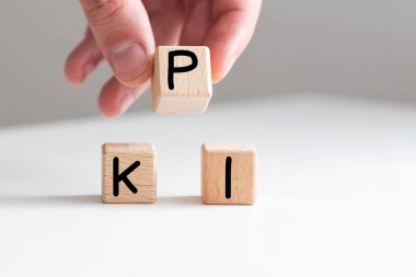 İş büyümesi konsepti başarı süreci. Erkek eli. Tahta bloklar ve KPI sözcüğüyle daireler ve beyaz arka planda basamak olarak dizilmiş oklar, kopyalama alanı. Yüksek kalite fotoğraf