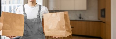 Paket yemek için çeşitli kağıt kaplar. Teslimatçı pizza taşıyor..