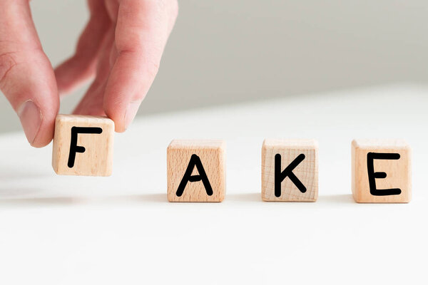 Слово "подделка" пишется деревянными буквенными плитками. Высокое качество фото