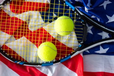Amerikan bayrağında yeni tenis topları olan bir tenis raketi. Yüksek kalite fotoğraf