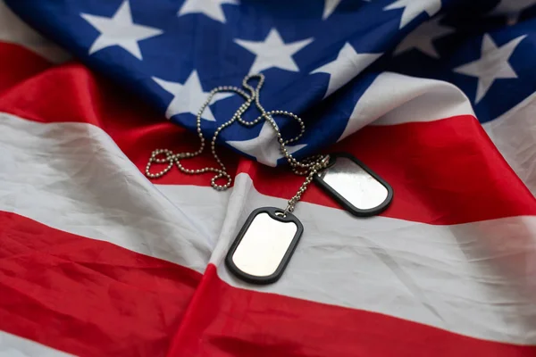 Dog tags and the flag of America. Focused on the dog tags. High quality photo