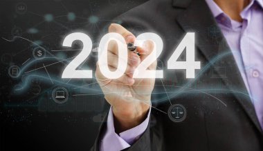 İş adamı 2024 harfini açık mavi duvarın üzerine bastırıyor, iş dünyası mutlu yıllar 2023 kapak konsepti. Yüksek kalite fotoğraf