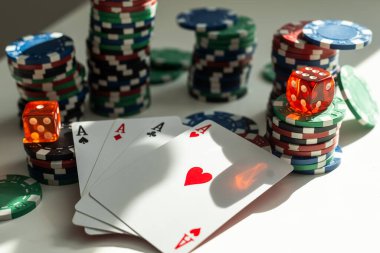 Poker fişleri, zarlar, iskambil kağıtları, bozuk paralar ve dolar banknotlarının beyaz arka planda izole edilmiş hali. Yüksek kalite fotoğraf