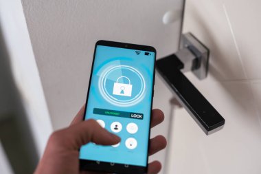 Otel kapısı güvenliği cep telefonundaki uygulamayla açılıyor. Dijital kapı kilidi, anahtarsız giriş kapısı sistemi. Yakın çekim ve seçici odaklanma. Yüksek kalite fotoğraf