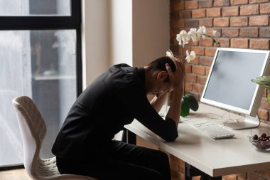 Hayal kırıklığına uğramış işadamı el başına Office ile masaya oturan