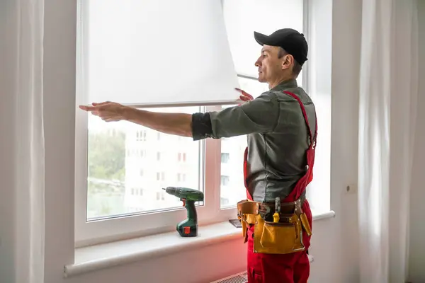 master puts a new double-glazed window in a plastic window. High quality photo