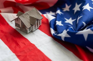Vatandaşlık, ikamet, mülk, gayrimenkul ve insan konsepti - Amerikan bayrağı üzerinde yaşam evi modeline yakın. Yüksek kalite fotoğraf
