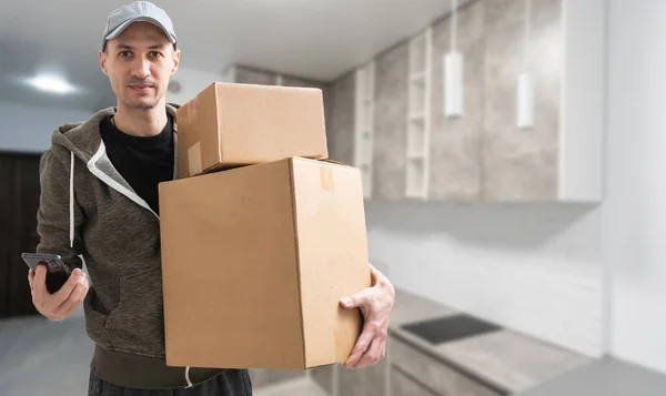 Man lifting cardboard boxes in apartment interior