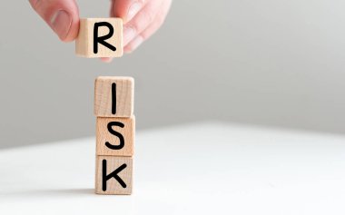 Sözcüklerle tahta küpleri istifleyen bir kadın. Beyaz arka planda risk, yakın plan. Yüksek kalite fotoğraf