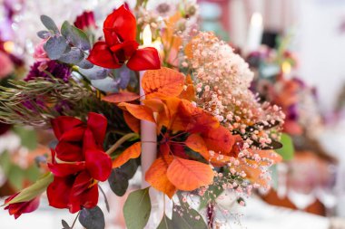 Çiçek kompozisyonu olan şenlikli masa için taşralı bir düğün süsü. Sonbahar düğünü.