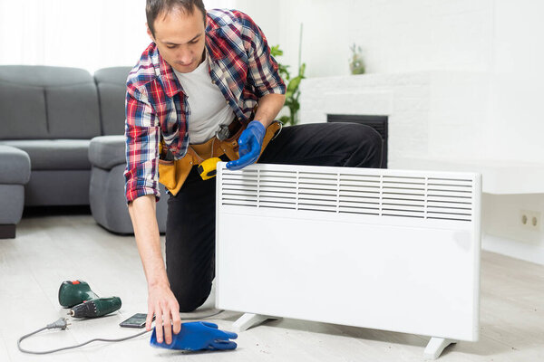service man with wrench near radiator. High quality photo