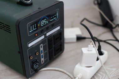 Taşınabilir elektrik santrali duvarın yanındaki cihazları şarj ediyor. Yüksek kalite fotoğraf