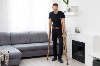 Koltuk değnekleriyle yaralı genç bir adam..