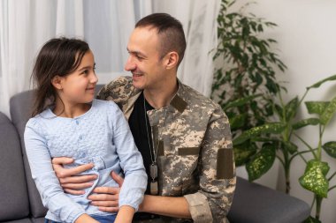 Sevgi kız babası kamuflaj ve geri dışarı kamera bakıyor.