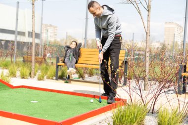 Bir adam mini golf oynamak için çarpışma yerine gider..