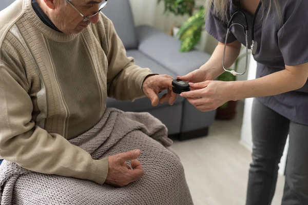 Nurse use pulse oximeter to check patients oxygen in home, Home healthcare service concept