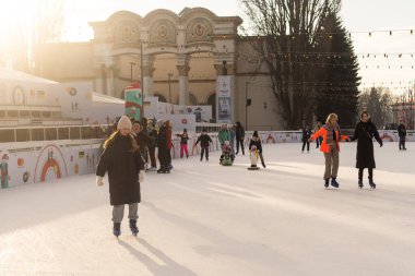 KYIV, UKRAINE - 23 Aralık 2022: buz pateni insanları. İnsanlar buz pateni sahasında eğleniyor. Kyiv 'de yeni yıl tatili. Kyiv Noel ve Yeni Yıl dekorasyonları