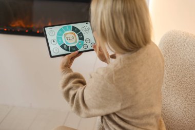 Bir tablet ile akıllı ev perde tutan bir kadın.