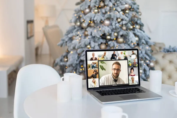 People on virtual call with family and friends exchanging gifts and celebrating virtual christmas online due to social distancing and coronavirus lockdown and quarantines. Image on computer screen