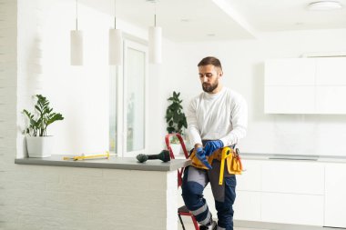 Apartmanın içine elektrik lambaları döşeyen elektrik işçisi. İnşaat dekorasyonu kavramı