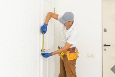 locksmith unscrew the door lock, locksmith repairs the lock in the front plastic door.