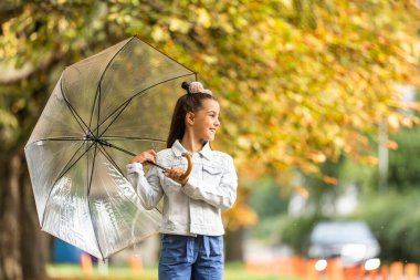Küçük çocuk şemsiye yağmur altında olarak ile yürüme düşmek park.