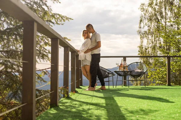 Happy couple at outdoor terrace in the mountains. Romantic time together.