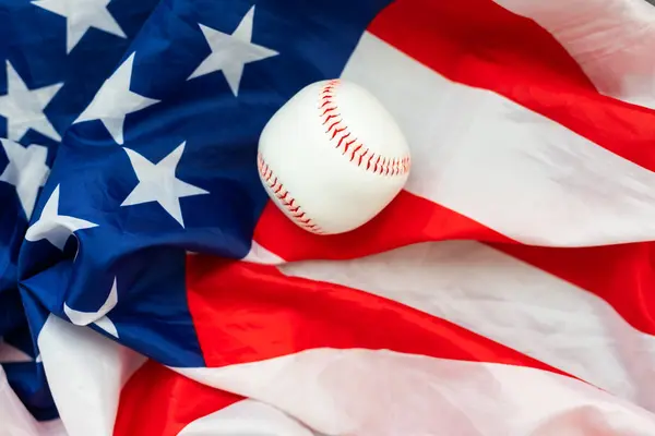 Baseball ball on American flag background for symbolic July 4th or Memorial day sports concept. High quality photo
