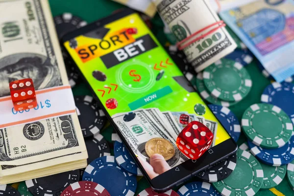 Mobile phone with bets, cards, chips, cubes and money dollars. Concept application for smartphone gambling, electronic casino online. High quality photo