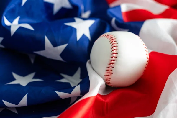 Baseball ball on American flag background for symbolic July 4th or Memorial day sports concept. High quality photo