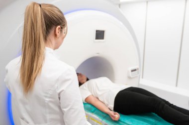 Modern hastane laboratuvarında bir hastaya tıbbi tomografi ya da MRI taraması yapın. Radyografi bölümünün içi. Beyaz odada teknolojik olarak gelişmiş ekipmanlar var. Manyetik rezonans tanılama makinesi.