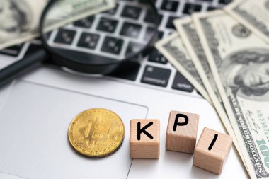 Finans ve ekonomi kavramı. Masanın üzerinde para, hesap makinesi, bir defter ve üzerinde KPI yazan küpler var. Yüksek kalite fotoğraf