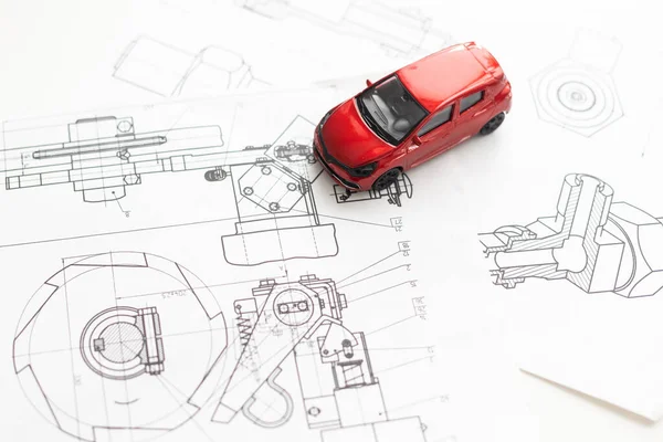 small car model and blueprint sheets. High quality photo