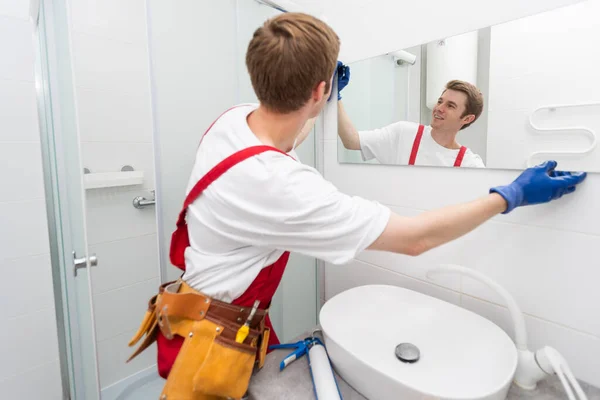 Arbetaren Installerar Spegeln Badrummet — Stockfoto