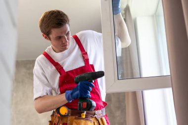 Yeni dairenin camlarını tamir eden bir tamirci.