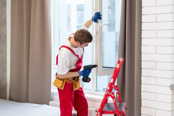 stock image Construction worker installing window in house.