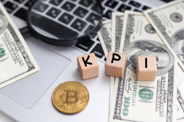 İş konsepti. Masanın üzerinde dolar, bir hesap makinesi ve üzerinde KPI yazan küpler var. Yüksek kalite fotoğraf